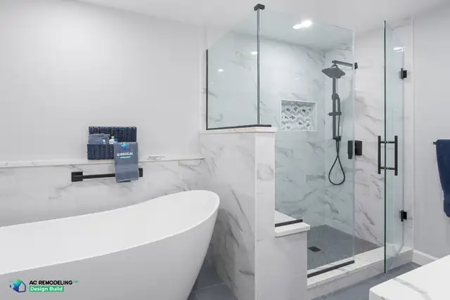 Primary bath in Gaithersburg with a freestanding soaking tub beside a marble-tiled walk-in shower with a glass panel