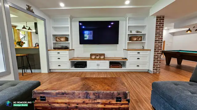 Finished basement remodel in Montgomery County with wall-mounted TV, white built-in cabinetry and warm wood counters