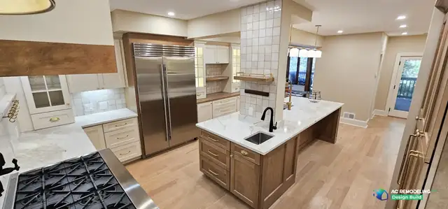 Bethesda, MD kitchen with stained wood island, prep sink, built-in Sub-Zero refrigerator and dining pendants