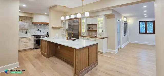 Open-plan Bethesda kitchen with cream cabinets, a stained wood island, brass pendants and white oak floors